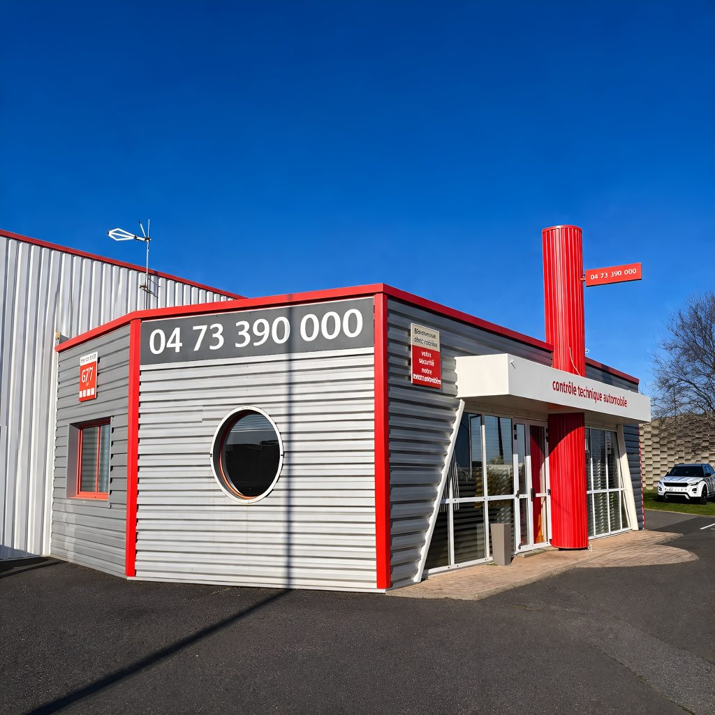Façade extérieure du centre de contrôle technique ControlAuto avec bâtiment gris, rouge et blanc