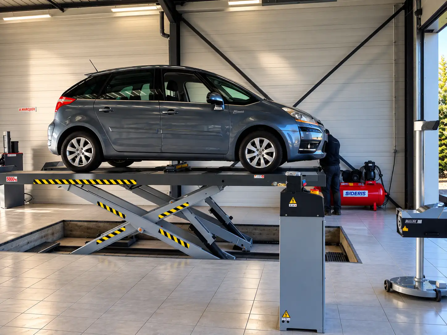 Voiture sur un pont élévateur dans l'atelier du centre ControlAuto de Thiers, près de Puy-Guillaume